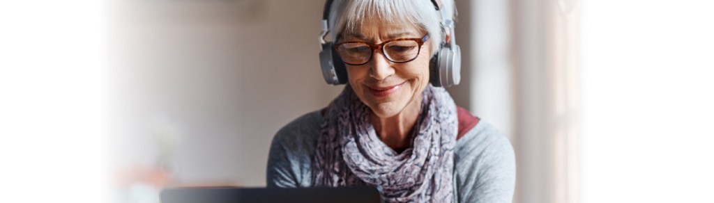 Signora che guarda un laptop con delle cuffie